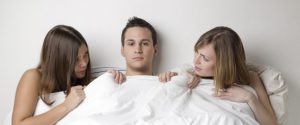 man and two women in bed,girls talking